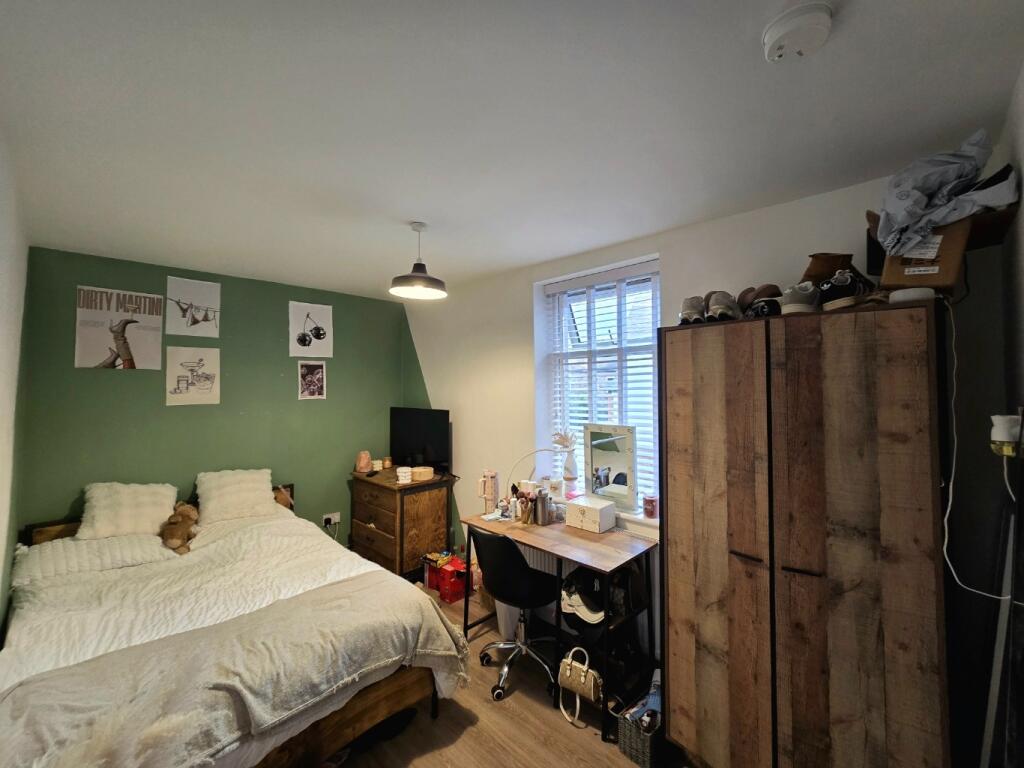 A cozy bedroom featuring a double bed and a war...