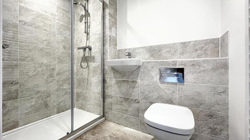 This modern bathroom features a sleek shower, s...