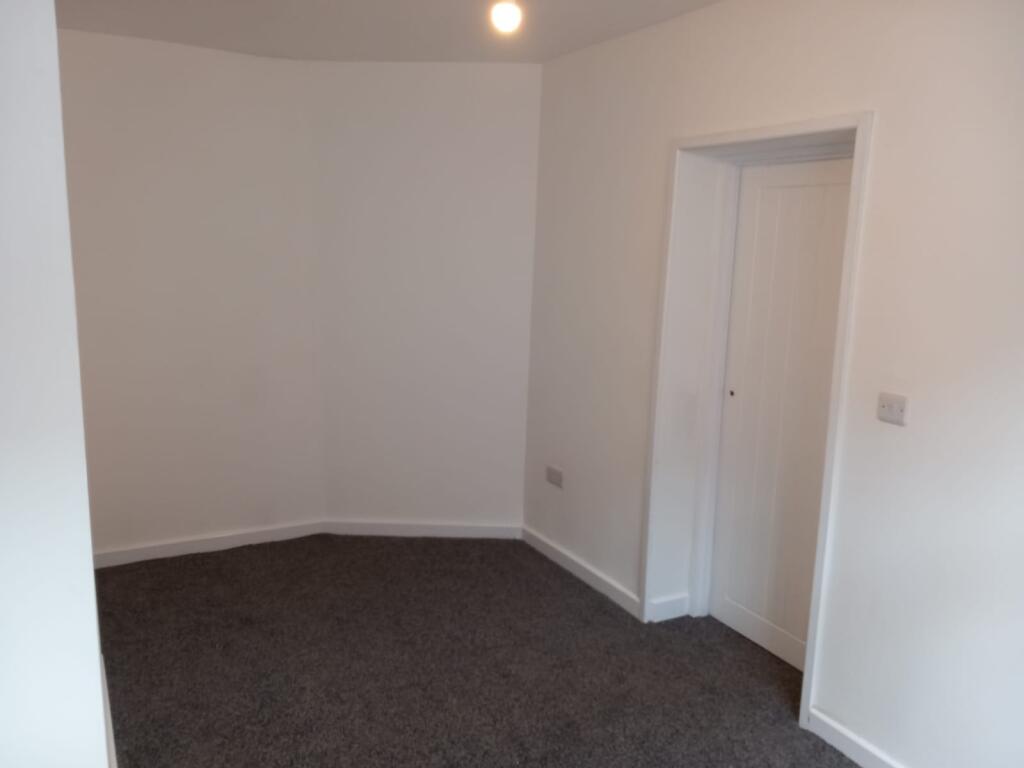 A clean, freshly painted small room featuring a...