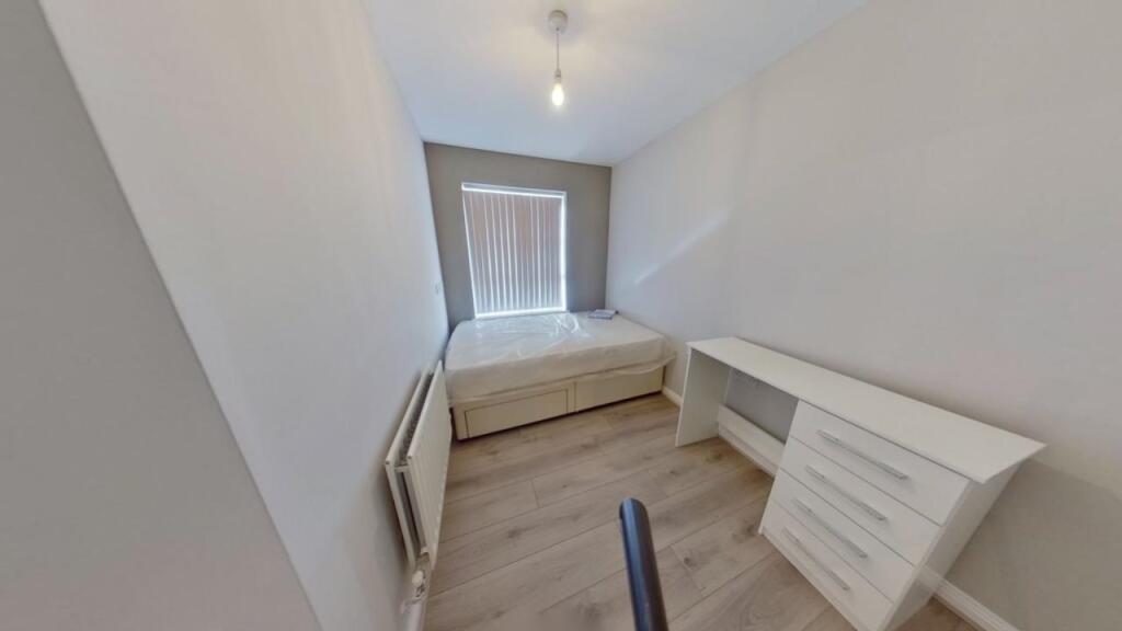 A neat and cozy single bedroom featuring a buil...