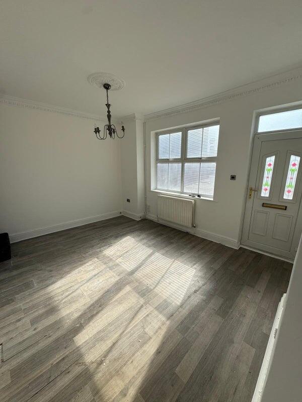 Bright and airy living room featuring large win...