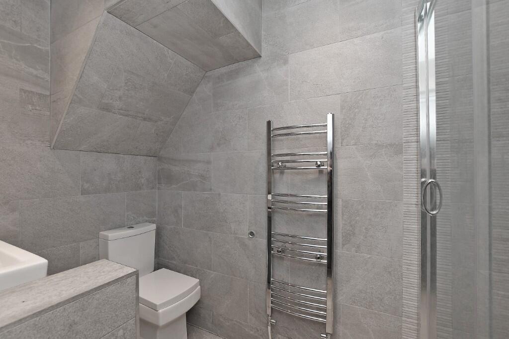 Modern bathroom featuring sleek grey tiles, a h...