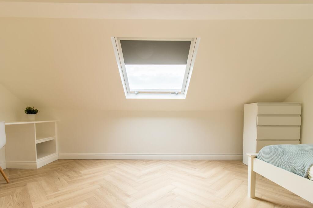 Bright and airy bedroom with a skylight window ...