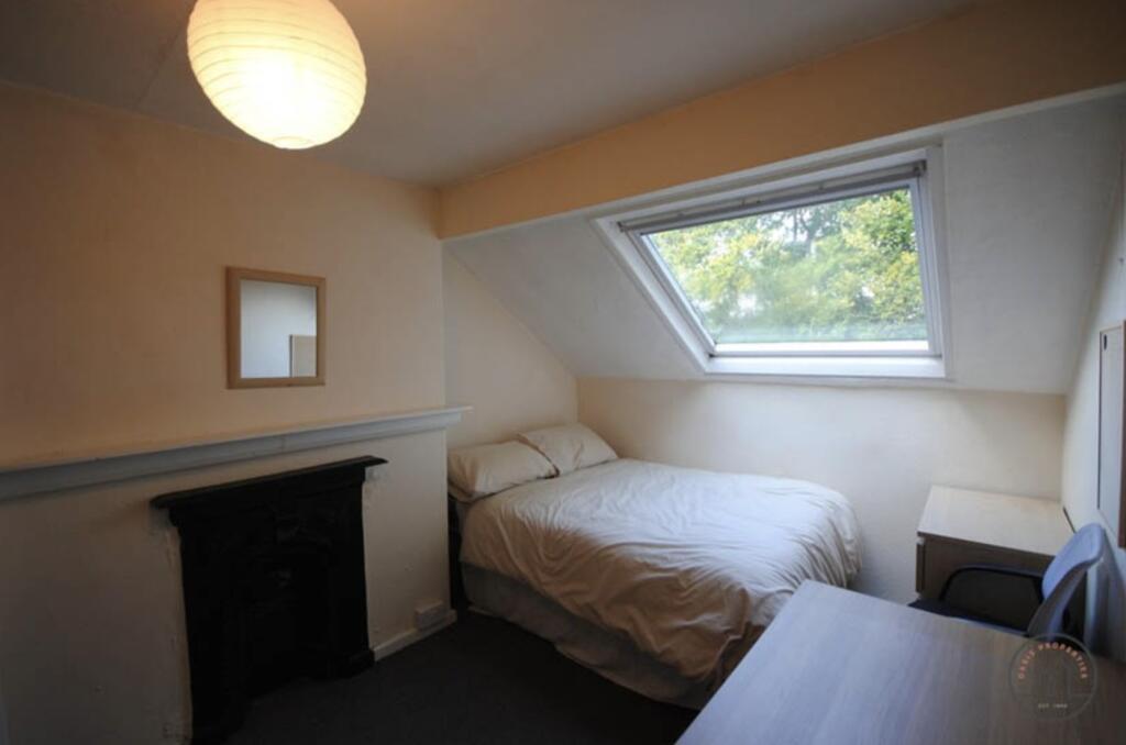 A cozy bedroom featuring a large window with am...