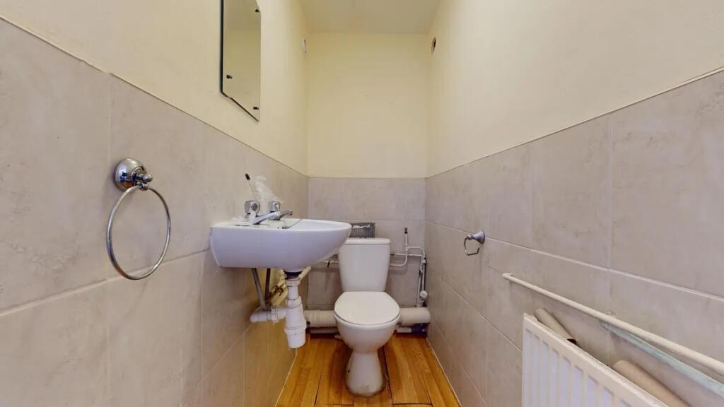 A compact and clean single toilet room featurin...