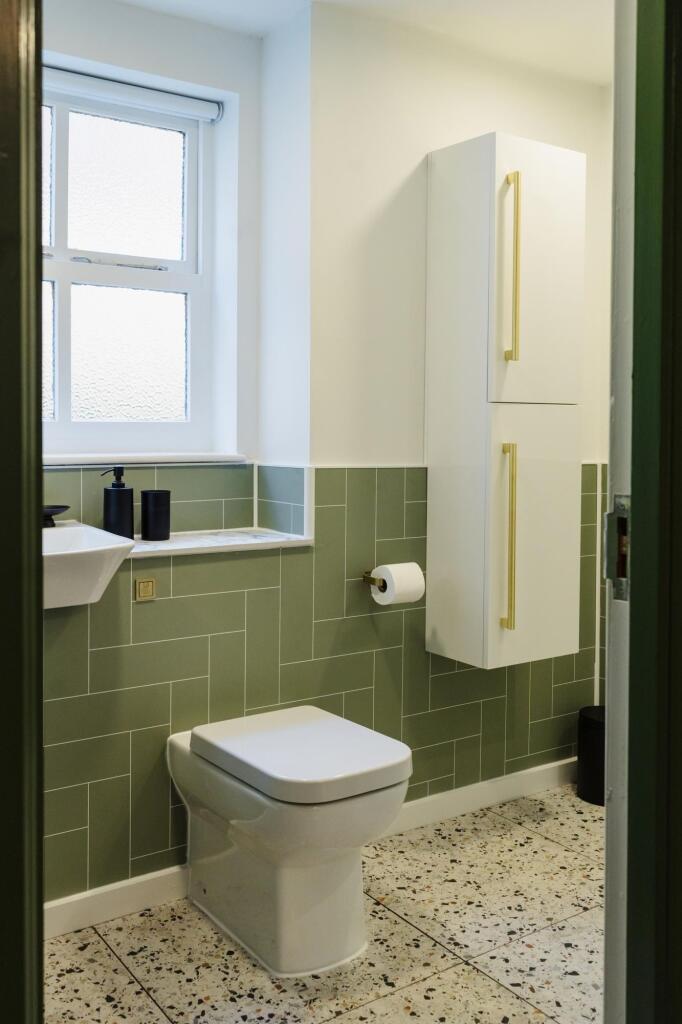 A clean and modern bathroom featuring a toilet,...