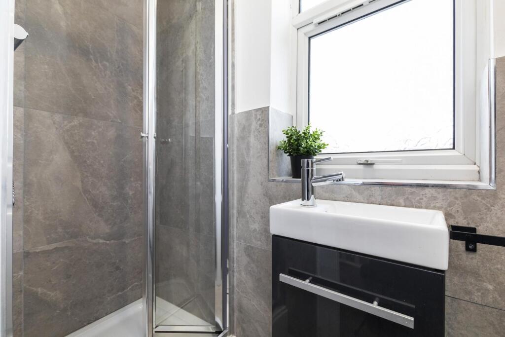 Bright, modern bathroom with a glass corner sho...