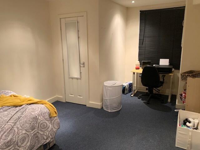 A cozy bedroom featuring a neatly made bed with...