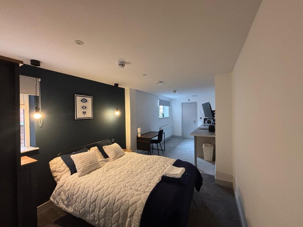 This cozy double bedroom features a comfortable...