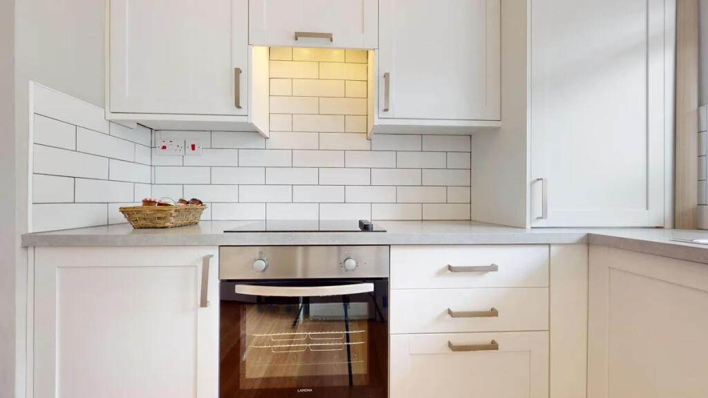 Bright and modern kitchen featuring sleek white...