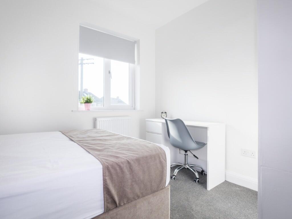 Bright and fresh single bedroom featuring a com...