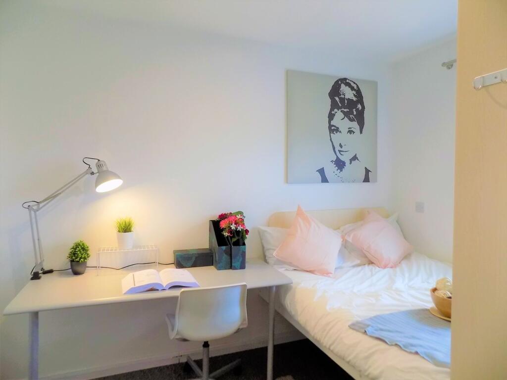 A cozy and neat single bedroom featuring a well...