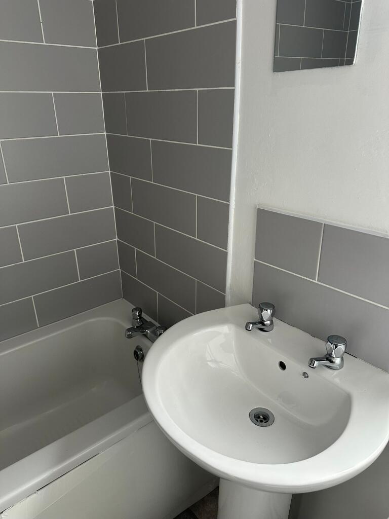 A clean bathroom featuring a white sink with du...