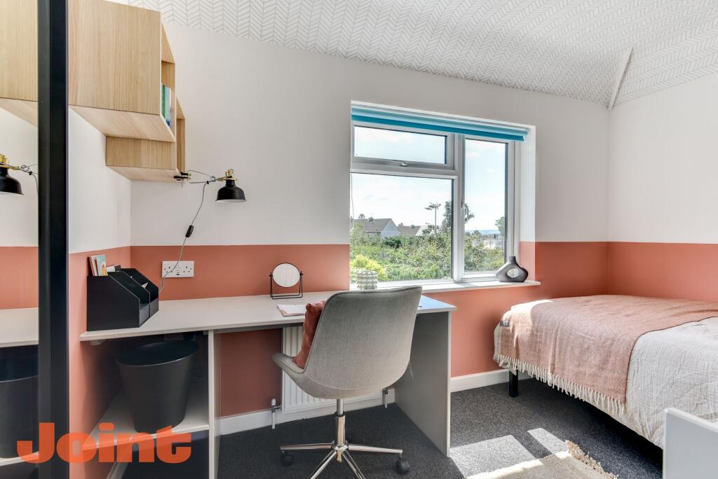 This inviting double bedroom features a cozy be...