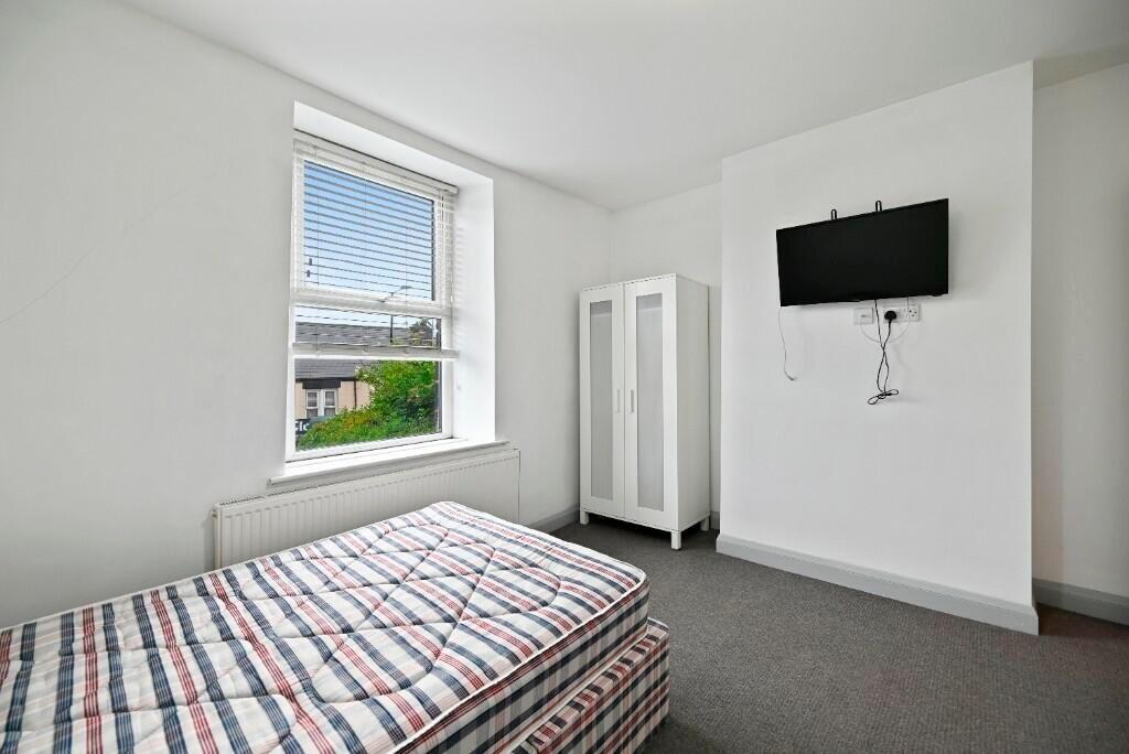 A bright and tidy single bedroom featuring a ne...