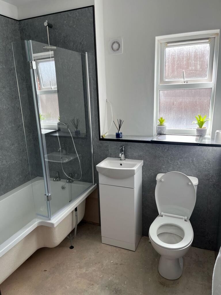 A modern bathroom suite featuring a white batht...