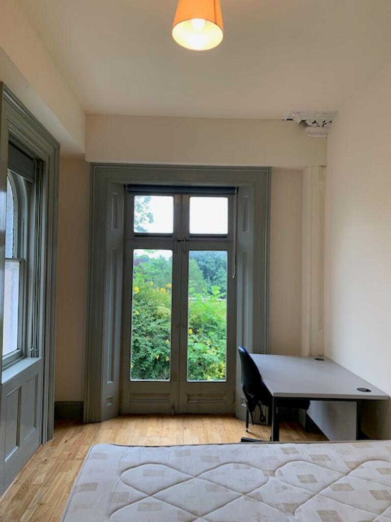 A spacious and bright double bedroom with large...