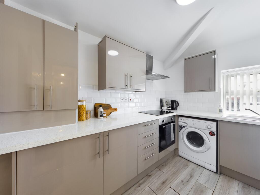 A modern and clean kitchenette with ample stora...