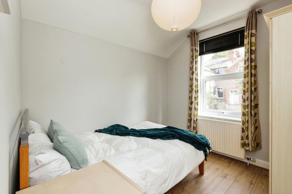 A bright and tidy bedroom featuring a comfortab...