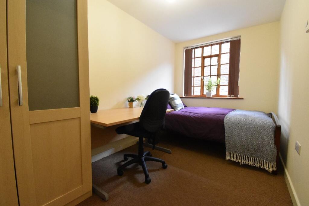 Cozy single bedroom featuring a comfortable bed...