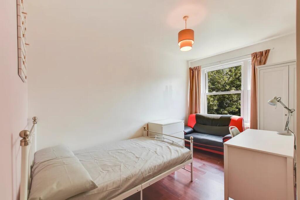 A bright and tidy single bedroom featuring a co...