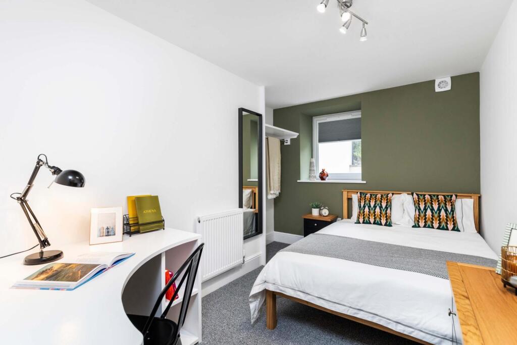 Bright, modern double bedroom with a comfortabl...