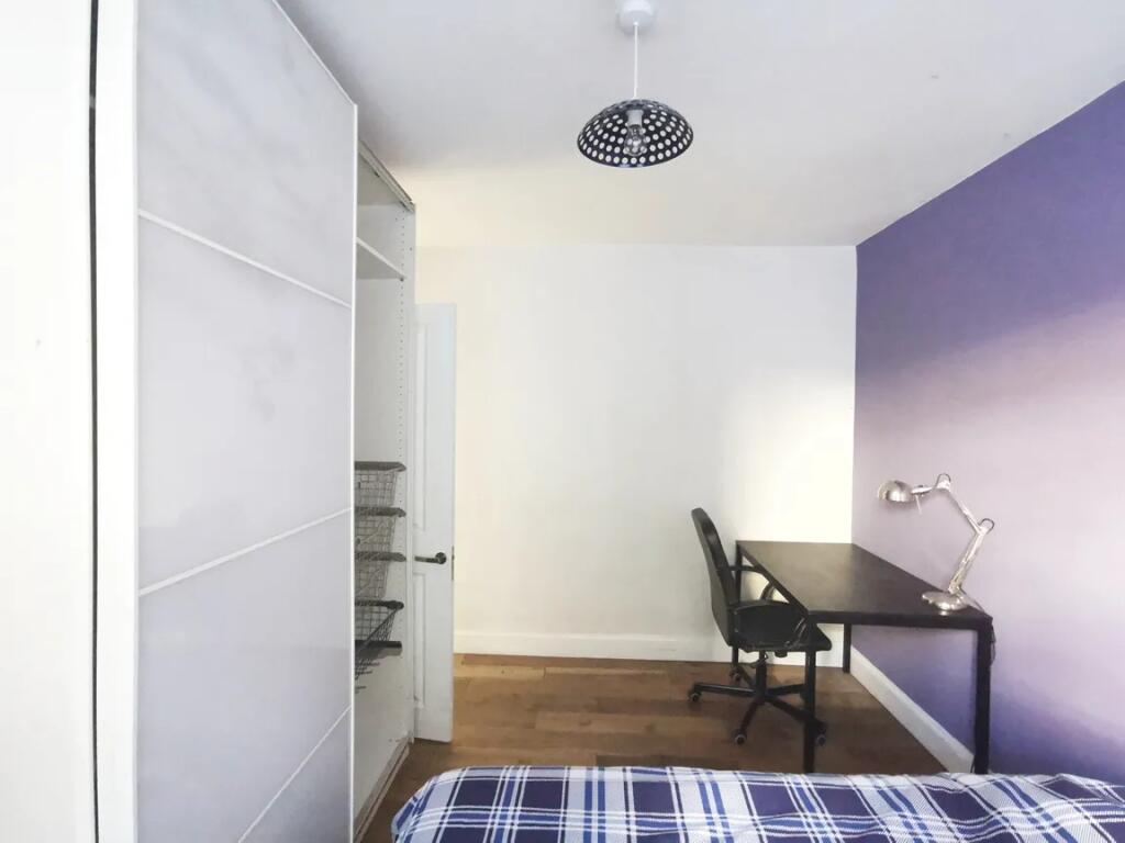 Bright and tidy bedroom featuring a comfortable...