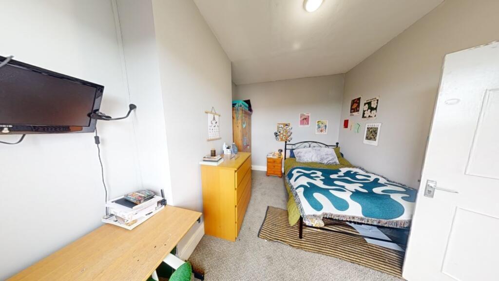 A bright and tidy single bedroom featuring a co...