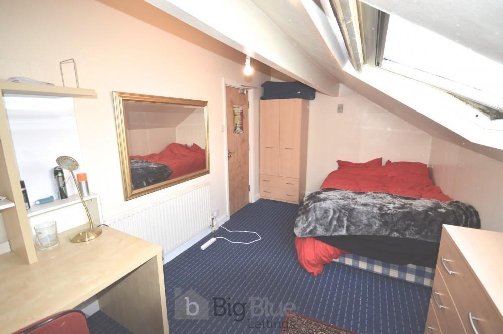 Cozy single bedroom featuring a comfortable bed...