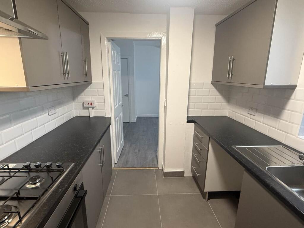 A modern, clean kitchen with ample workspace, w...