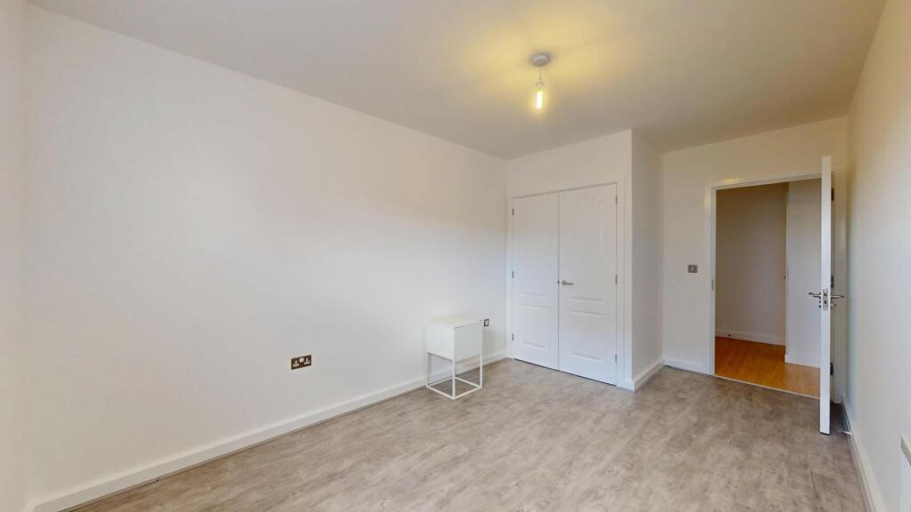 A bright double bedroom featuring a built-in wa...