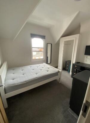 A cozy double bedroom with a white bed frame an...