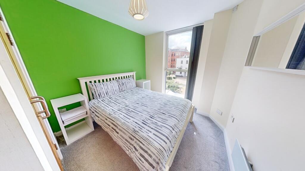 Bright single bedroom with a fresh green accent...
