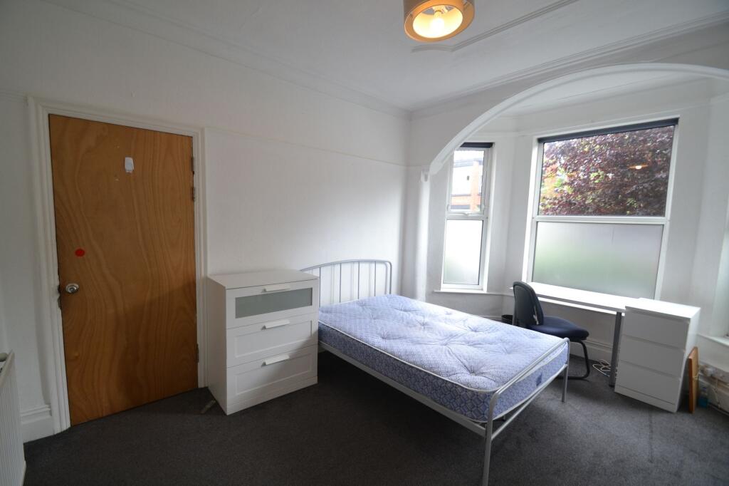 A tidy single bedroom featuring a metal bed fra...