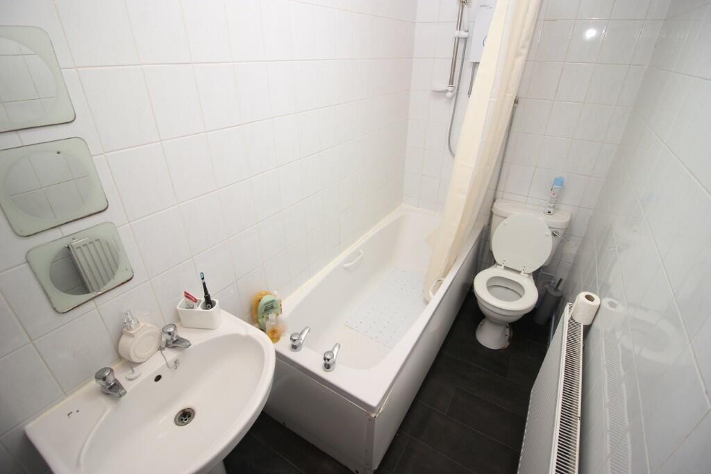 A compact and clean bathroom featuring a bathtu...