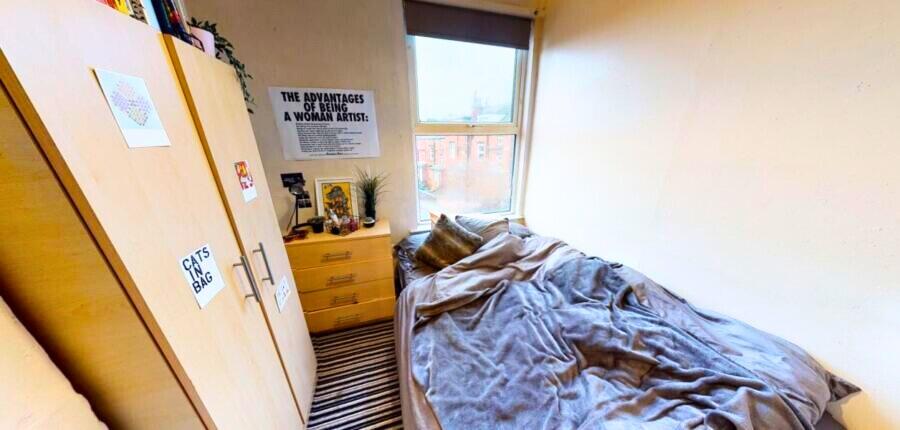 Cozy single bedroom featuring a large window th...