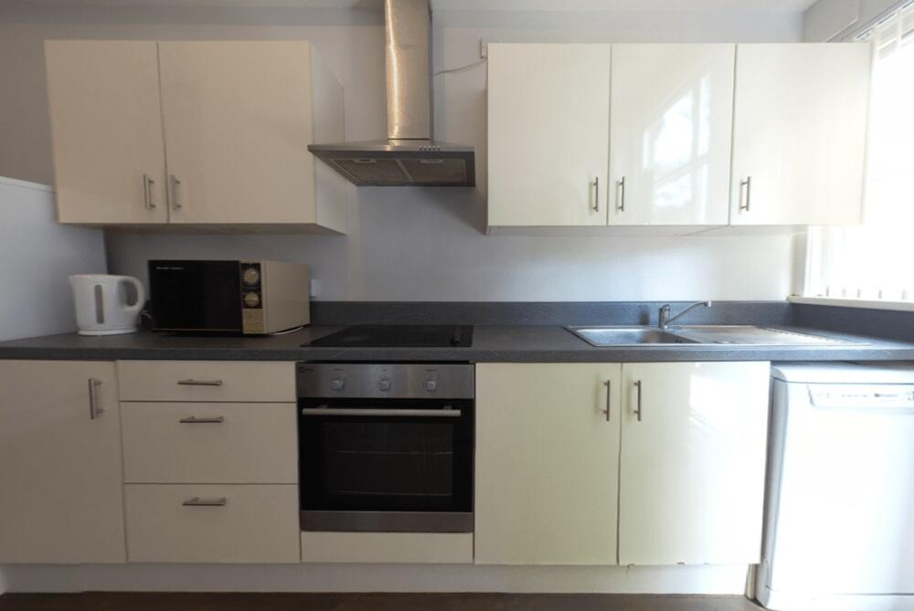 Bright and modern kitchen with white cabinets a...