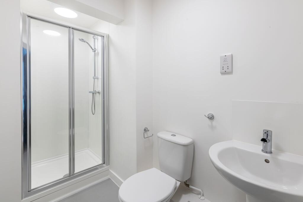 Bright and modern bathroom suite featuring a sl...