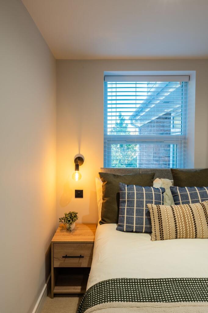 Well-styled bedroom corner with a comfy double ...