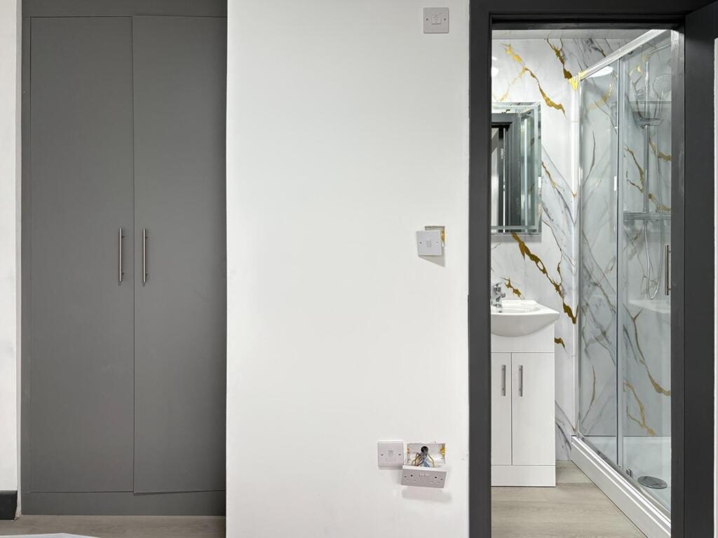 Bright, modern bathroom with a glass shower enc...