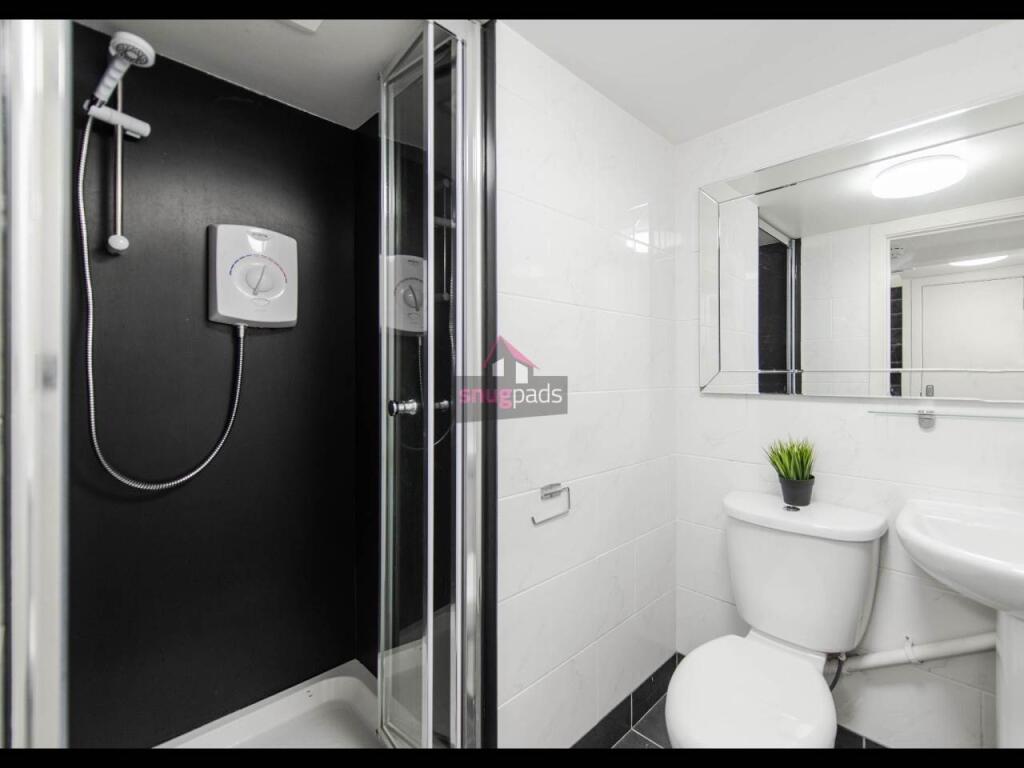 A clean and modern bathroom with a spacious sho...