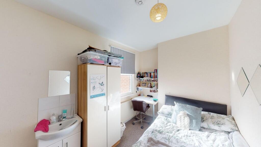 A cozy single bedroom featuring a neatly made s...