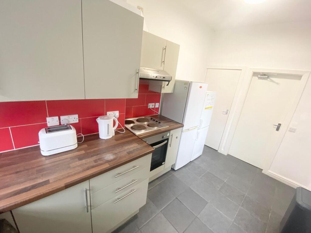 Modern kitchen with clean cabinetry, a wooden c...