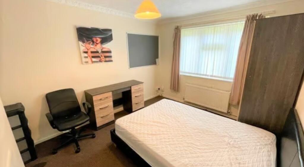 A cozy double bedroom featuring a large window ...