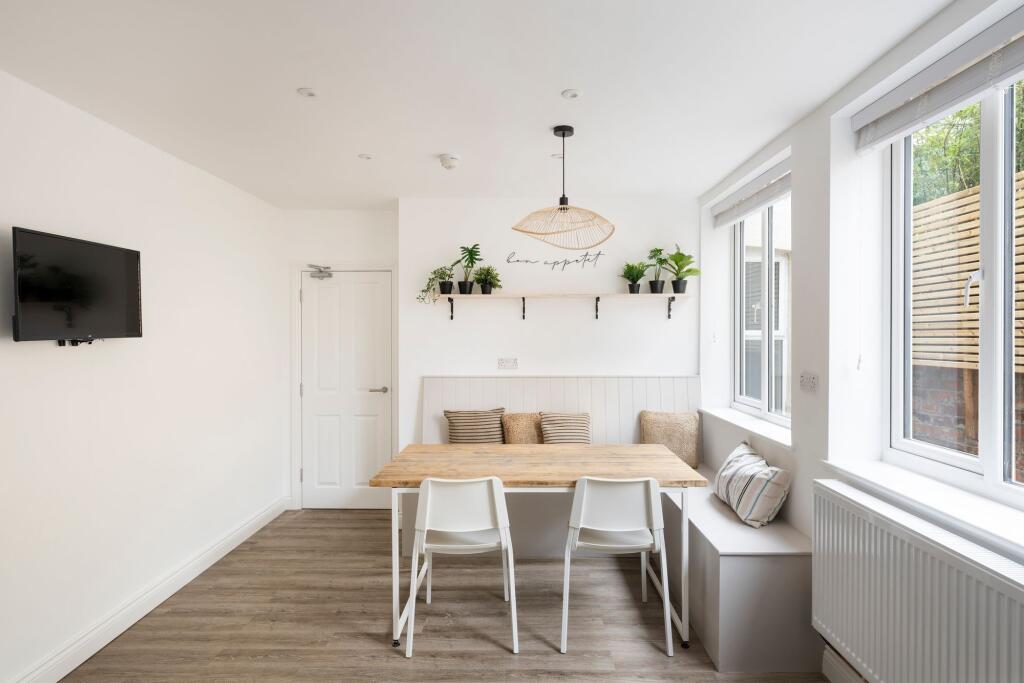 Bright, modern dining nook with a wooden table,...