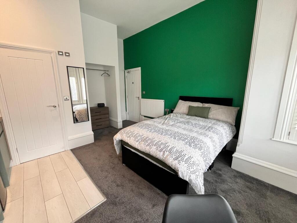 This inviting double bedroom features a cozy la...