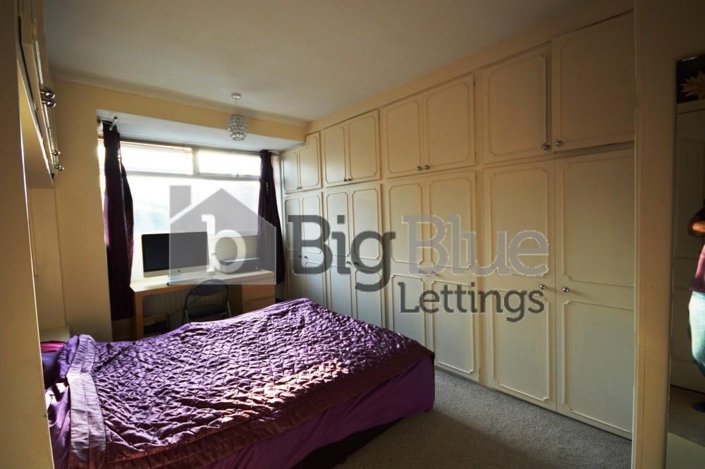Well-lit master bedroom featuring a large windo...