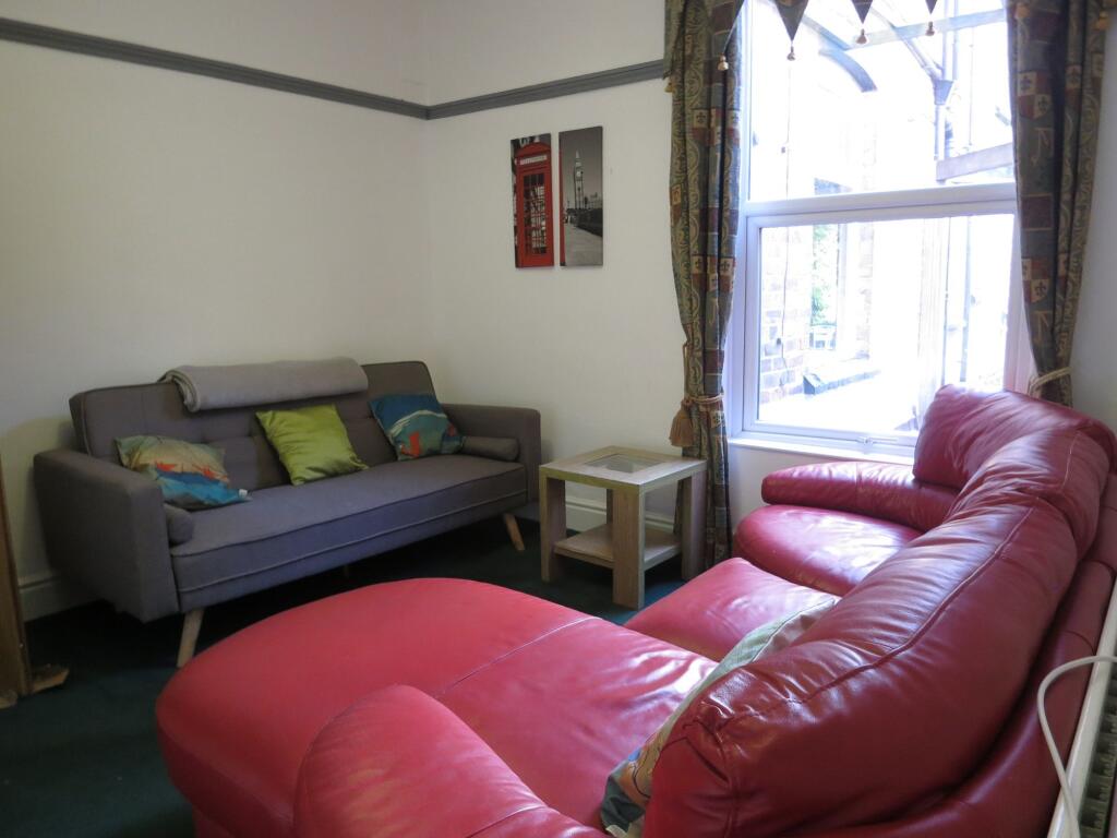 A bright, welcoming living room featuring a lar...