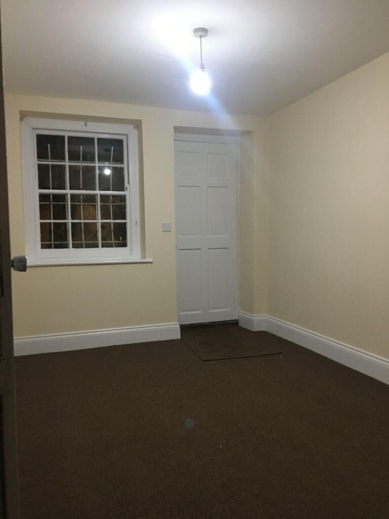 Empty bedroom with neutral walls, a sash-style ...