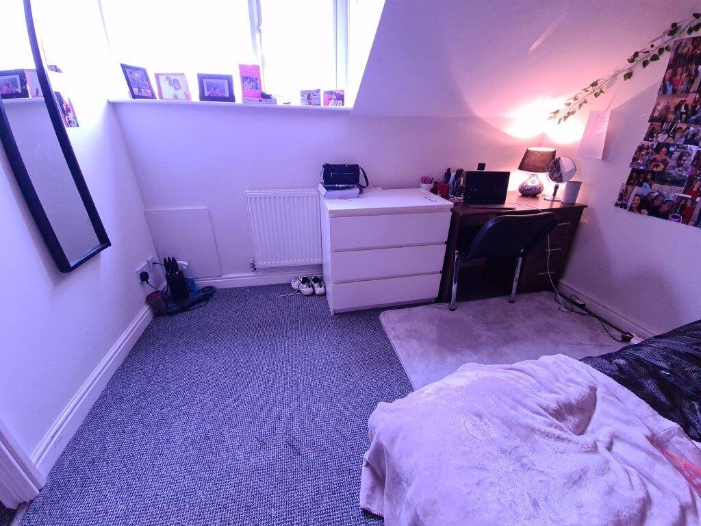 A neat and well-lit room corner with carpeted f...